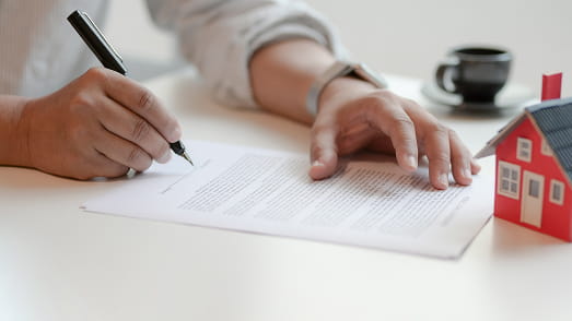 Imagem de uma pessoa assinando um contrato